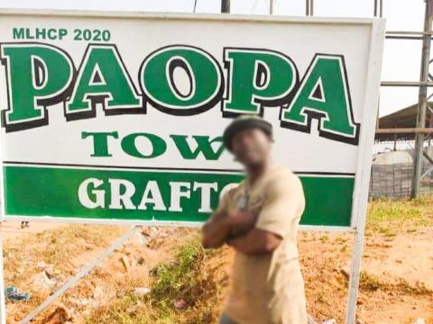 A man poses in front of a sign post at Paopa Town in Grafton