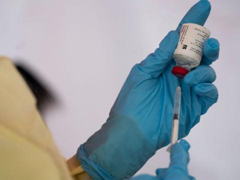 A medical personnel administers an Ebola vaccine dose