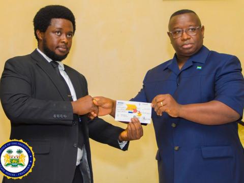 Ben-Kaifala hands over the cheque to President Bio