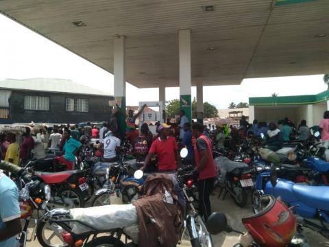 Bike riders scramble for fuel at an NP station in Bo