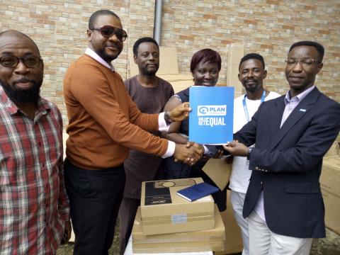 Evariste Sindayigaya of Plan presents donated items to officials of the First Lady's office