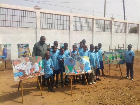 children displaying their drawings.